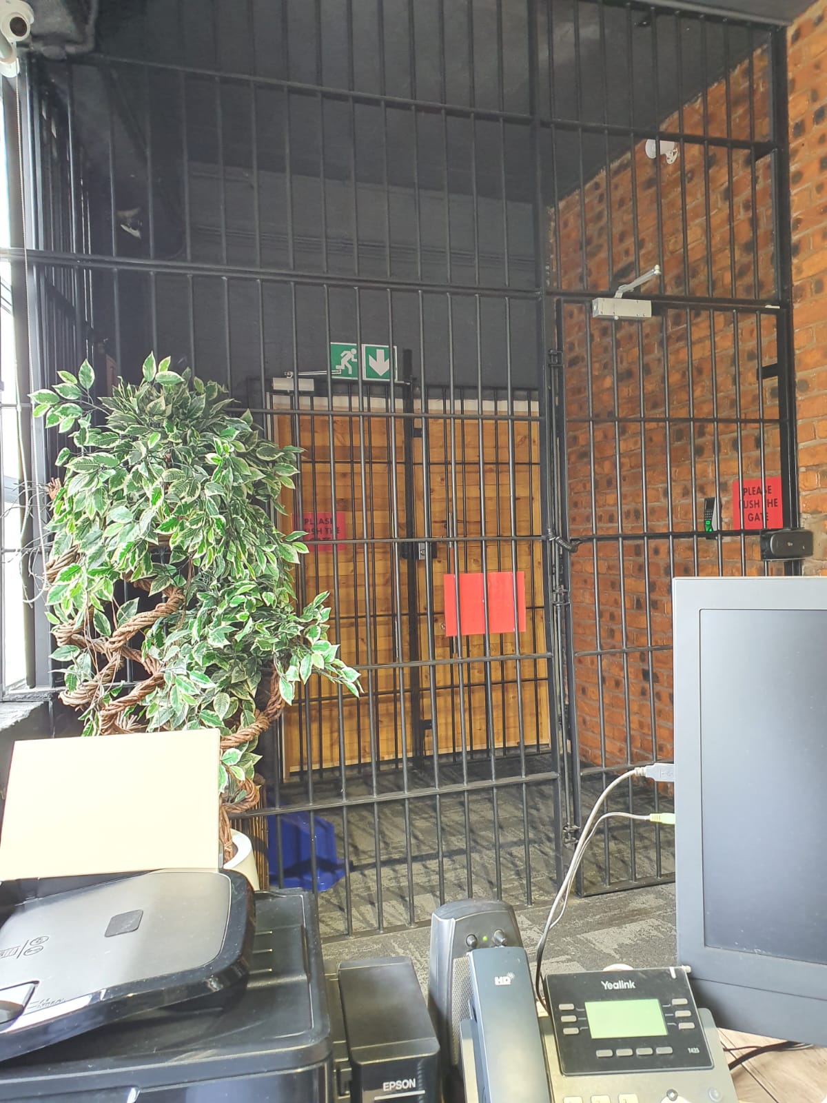 Black steel security gate at the CARTEL offices with reception equipment in front