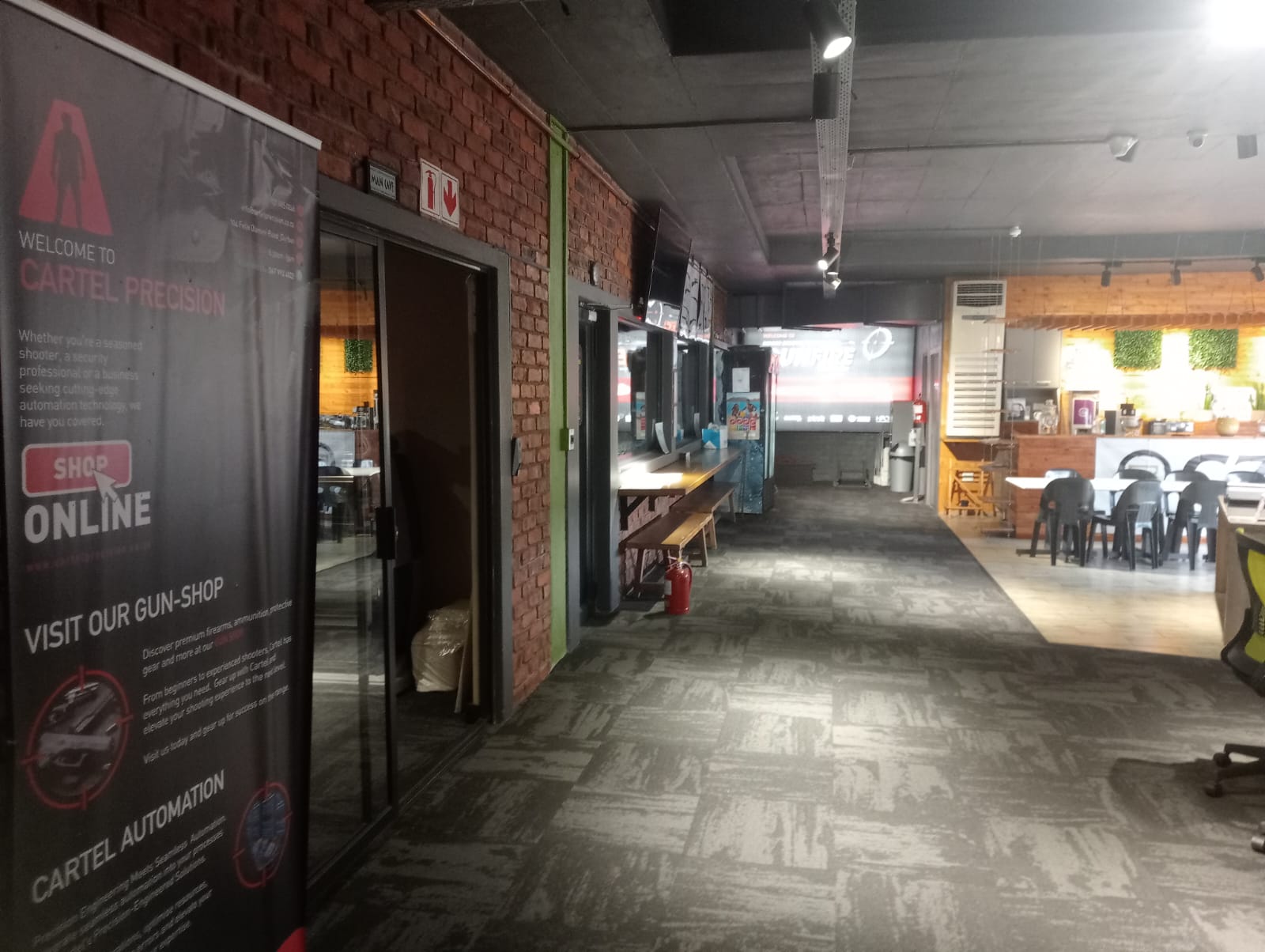 CARTEL PRECISION pull-up banner in the entrance corridor beside the in-store counter